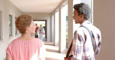 Lise koridorunda konuşuyorlar, gençler gülümsüyor ve sohbetlerinden zevk alıyorlar. Arkadaşlık, mutluluk, sosyalleşme, yaşam tarzı, gençlik, dostluk