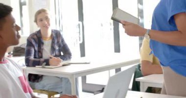 Lisede, öğrenciler sınıfta dizüstü bilgisayar ve tablet kullanıyorlar, derslere odaklanıyorlar. Eğitim, teknoloji, öğrenim, öğrenim, dijital, modern