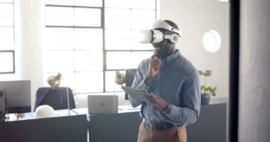 VR kulaklığı kullanarak, iş adamı tablet tutuyor ve modern ofiste gülümsüyor. Teknoloji, yenilik, girişimci, şirket, sanal gerçeklik, profesyonel