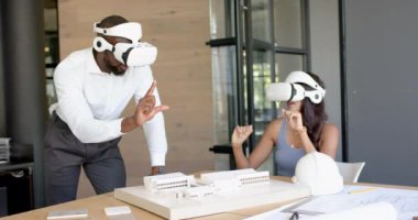 VR kulaklıkları kullanarak, çeşitli iş arkadaşları ofiste mimari modellerle uğraşıyorlar. Teknoloji, sanal gerçeklik, işbirliği, takım çalışması, tasarım, mimari