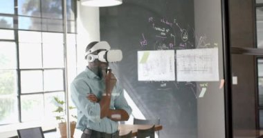 VR kulaklığı kullanan işadamı, modern ofisteki yapışkan notlarla ilgili verileri analiz ediyor. Teknoloji, yenilik, beyin fırtınası, analiz, verimlilik.