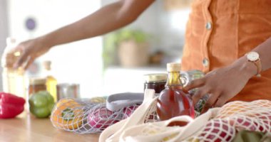 Mutfak tezgahına erzak koymak, kadın taze sebze ve kavanozları açmak. Market, yemek, yemek, alışveriş, sağlıklı, üretim