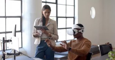 Afro-Amerikan erkek, kadın tableti tutarken sanal arayüzle etkileşime geçiyor. Teknoloji, sanal gerçeklik, etkileşim, yenilik, işbirliği, dijital