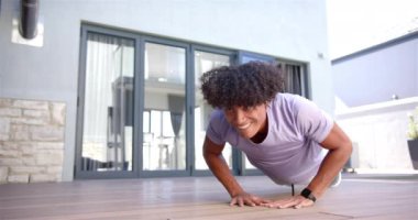 Şınav çeken, evdeki ahşap zeminde egzersiz yapan, akıllı gözlüklü, fotokopi çeken bir adam. Spor, egzersiz, spor, spor salonu, güç, eğitim