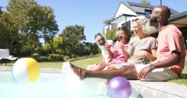 Havuzda dinlenirken, kıdemli arkadaşlar güneşli bir günde içki içip sohbet ediyorlar. Rahatlama, arkadaşlıklar, boş zaman, yaz, açık hava, tatil