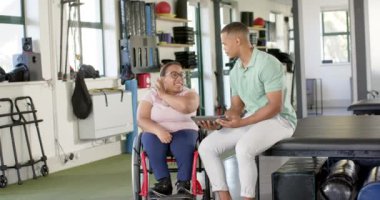 Rehabilitasyon merkezinde, tekerlekli sandalyede belden aşağısı felçli bir kadına tablet gösterip terapiyi tartışıyorduk. fizyoterapi, sağlık, sağlık, iyileşme, tedavi, hasta, değişmemiş, yavaş çekim