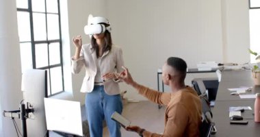 VR kulaklık kullanan bir kadın, meslektaşı ile ofisinde tablet tutarken etkileşime geçiyor. Teknoloji, sanal gerçeklik, işbirliği, işbirliği, iş birliği, yenilik
