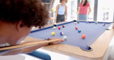 Evde, bilardo oynarken, çeşitli arkadaşlar rahat bir ortamda oyun oynuyorlar. Bilardo, eğlence, eğlence, oyun gecesi, eğlence, sosyalleşme.
