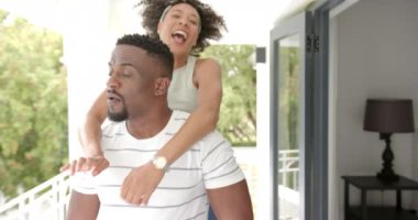 Gülen çift birlikte eğleniyor, kadın arkadan şakacı bir şekilde sarılıyor. Mutluluk, birliktelik, neşe, şefkat, ilişki, bağ