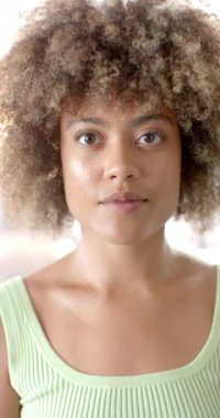 Dikey video: Yeşil tişörtlü gülümseyen kadın arkadaşlarıyla eğleniyor, mutlu hissediyor. Mutluluk, yaşam tarzı, eğlence, kahkaha, bağlanma, birliktelik