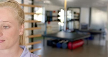 Özürlü rehabilitasyon merkezinde arka planda egzersiz ekipmanları olan gülümseyen kadın, kopyalama alanı. Rehabilitasyon, sağlık, fizik tedavi, fitness, sağIık, iyileşme, değişmemiş, yavaş çekim