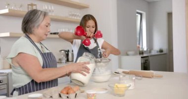 Birlikte yemek pişirmek, Asyalı büyükanne ve çocuk un ölçüp mutfakta elemek. Aile, birliktelik, yemek pişirme, bağ kurma, çocukluk