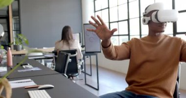 VR kulaklığı kullanarak, Afrikalı Amerikalı adam modern ofis çalışma alanında onay veriyor. Sanal gerçeklik, teknoloji, onay, yenilik, iş gelişigüzel