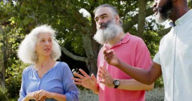 Kıdemli arkadaşlar konuşuyor ve parkta eğleniyorlar, gülümsüyorlar ve gülüyorlar. Arkadaşlık, sosyalleşme, mutluluk, yaşam tarzı, bağlanma, rahatlık