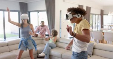 Evde, VR oyunları oynarken, farklı arkadaşlar oturma odasında sanal gerçeklik deneyiminin tadını çıkarıyorlar. oyun, teknoloji, eğlence, eğlence, VR kulaklık, dijital