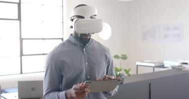 VR kulaklığı kullanarak, iş adamı tablet tutuyor ve modern ofiste çalışıyor. Teknoloji, yenilik, girişimcilik, çalışma alanı, şirket, dijital