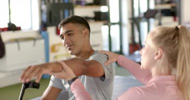 Engelli rehabilitasyonunda kadın terapistin yardımıyla kol egzersizi yapan bir adam. Fizyoterapi, rehabilitasyon, sağlık, tıbbi, terapi, iyileşme, değişmemiş, yavaş çekim