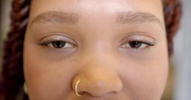 Burun halkalı, gülümseyen bir kadın, yüzüne yakın çekim, mutluluk ve neşe gösteriyor. Portre, yüz ifadesi, mücevher, olumlu, neşeli