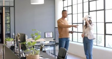 İş arkadaşları modern ofis ortamında VR kulaklığı kullanarak işbirliği yapıyorlar. Teknoloji, yenilik, takım çalışması, işbirliği, sanal gerçeklik, buluşma