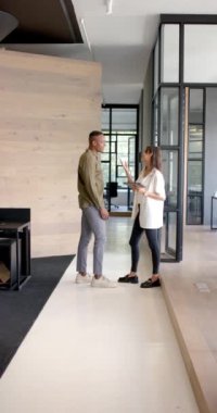 Dikey video: İş görüşmesi, iş arkadaşlarının modern ofis koridorunda durması. Takım çalışması, işbirliği, profesyonellik