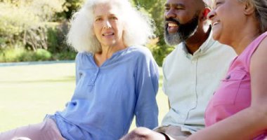 Gülümseyen kıdemli arkadaşlar dışarıda oturuyor, sohbet ediyor ve birlikte gülüyorlar. Arkadaşlık, mutluluk, yaşam tarzı, eğlence, bağlanma, toplum