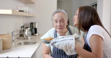 Taze kek pişirmek, Asyalı büyükanne ve torun gülümsemek ve mutfakta eğlenmek. Aile, kaynaşma, yemek pişirme, nesiller arası