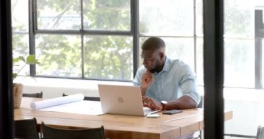 Dizüstü bilgisayarla çalışan, ofiste masa başı işlerle uğraşan bir adam. işyeri, üretkenlik, teknoloji, profesyonel, kurumsal, girişimci