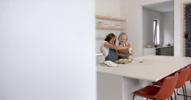 Birlikte yemek pişirmek, Asyalı büyükanne ve torun modern mutfakta kek süslemek. aile, bağ, jenerasyon, birliktelik, etkinlik, ev yapımı