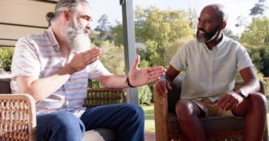 Dışarıda teras sandalyelerinde otururken kıdemli arkadaşlar konuşuyor ve el kol hareketi yapıyorlar. Arkadaşlık, sohbet, rahatlama, olgunlaşma, bağlanma, rahatlama.