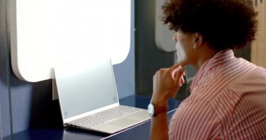 Dizüstü bilgisayar kullanıyor, çizgili gömlekli adam modern ofis ortamında çalışıyor. Teknoloji, üretkenlik, iş, meslek, işyeri