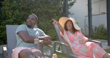 Bilardoda dinlenen Afro-Amerikan çift, arka bahçede içki ve güneşin tadını çıkarıyor. Tatil, eğlence, rahatlama, açık hava, yaşam tarzı, keyif