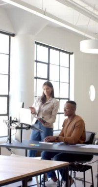 Dikey video: Modern ofiste işbirliği, tablet ve masaüstü tartışma projelerini kullanan meslektaşlar. Takım çalışması, işbirliği, teknoloji, dijital, beyin fırtınası, yenilik