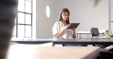 Tableti tutan, masa başında oturan ve ofisteki pencereden dışarı bakan bir iş kadını. teknoloji, kurumsal, profesyonel, çalışma alanı, tefekkür, girişimci