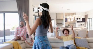 Evde çeşitli arkadaşlarla sanal gerçeklik oyunundan hoşlanan bir kadın. Teknoloji, oyun, eğlence, kapalı alan, boş zaman, eğlence