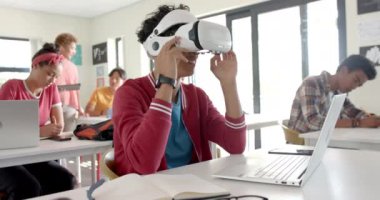 VR kulaklığı kullanan liseli bir genç sanal çevreyle etkileşime giriyor. Sanal gerçeklik, eğitim, teknoloji, öğrenci, öğrenme, etkileşim