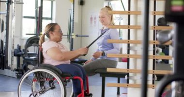 Direniş bandıyla egzersiz, tekerlekli sandalyeli kadın terapistle, rehabilitasyon merkeziyle. fizyoterapi, egzersiz, fitness, eğitim, sağlık, terapi, değişmemiş, yavaş çekim