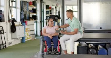 Rehabilitasyon merkezi, tablet kullanan terapist ve tekerlekli sandalyedeki felçli kadını destekleyen kadın. Fizyoterapist, sağlık, sağlık, engellilik, yardım, iyileşme, değişmemiş, yavaş çekim