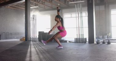 Kettlebell 'le tek bacaklı çömelme, spor salonunda egzersiz yapan bir kadın. Spor, spor, egzersiz, güç, eğitim, denge
