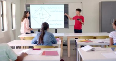 Kırmızı tişörtlü iki ırklı çocuk gemide bir matematik problemi oluşturuyor. Genç bir melez kadın dikkatle dinlerken, diğer öğrenciler değişmeden, parlak bir sınıfa odaklanıyorlar.