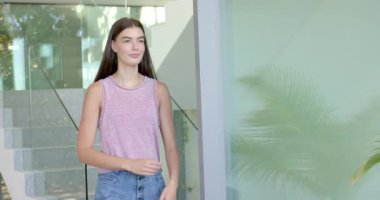 Kolları çapraz duran, gözleri kapalı, kopyalama alanı olan beyaz bir kadın. Pembe kolsuz bluz giyiyor, uzun kahverengi saçlı, açık tenli, değişmemiş, ağır çekimde.