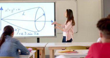 Asyalı ergen bir kız lise sınıfında matematik problemi sunuyor. Nişanlı öğrenciler, beyaz tahtadaki geometrik kavramları yavaş çekimde anlatırken onu dinliyorlar..