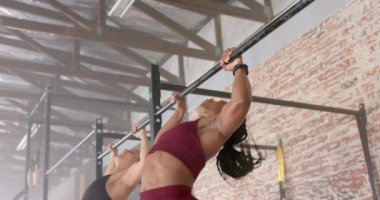 Barfiks çekmek, kadınlar spor salonunda egzersiz yapmak, vücudunun üst kısmına odaklanmak. Spor, spor, egzersiz, eğitim, atletik, kararlılık