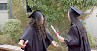 Mezunlar başarılarını dışarıda kutluyorlar. Tanımlanamayan genç kız ve Asyalı genç kız lisede zaferin tadını çıkarıyorlar, ağır çekimde..