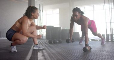 Spor salonunda antrenman, kadın, antrenör izlerken halterlerle şınav çekiyor. Fitness, egzersiz, güç, kişisel antrenör, egzersiz, halter