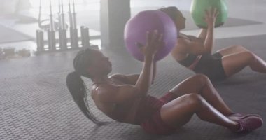 İlaç toplarıyla egzersiz yapmak, spor salonunda yatan kadınlar, vücut kaslarını güçlendirmek. Fitness, egzersiz, egzersiz, sağlıklı, eğitim, kondisyon