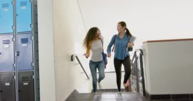 Parlak bir lise koridorunda, çeşitli bir grup öğrenci merdivenlerden iniyor. Grupta koyu saçlı beyaz bir erkek, Afro-Amerikan bir kadın ve değişmemiş İspanyol bir erkek yer alıyor.