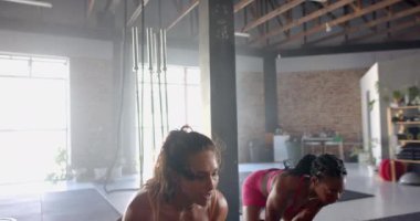 Spor kıyafetleri giymiş, spor giyinmiş, spor partnerinin yanında duran, spor salonunda gülümseyen, formda bir kadın. Fitness, egzersiz, ortaklık, motivasyon, sağlık, yaşam tarzı