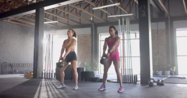 Kettlebell egzersizi, spor salonunda esneyen ve spor yapmaya odaklanan iki kadın. egzersiz, egzersiz, güç, eğitim, esneklik, sağIık