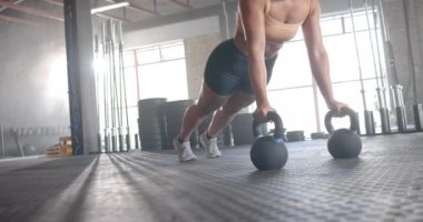 Kettlebell kullanarak şınav çeken, spor salonunda spor yapan, fotokopi çeken bir kadın. egzersiz, egzersiz, güç, eğitim, sağlık, atlet