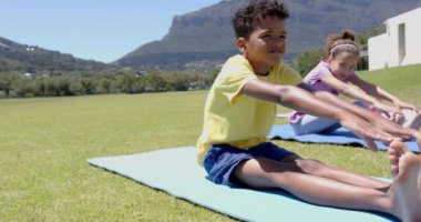 Yoga minderleri üzerinde gerinmeler, okul alanında dışarıda egzersiz yapan çocuklar. Fitness, egzersiz, sağlık, aktivite, değişmemiş, yavaş çekim